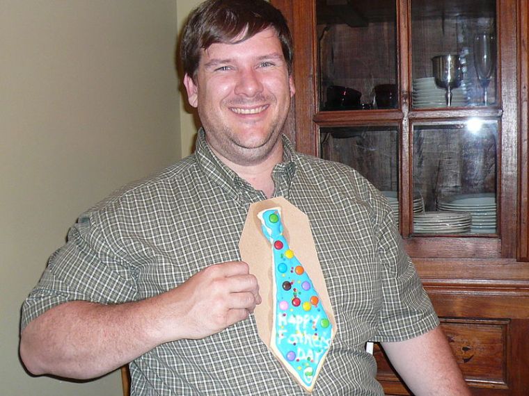 A father holding a necktie cookie on Father's Day. Author: Dean Michaud, originally posted on Flickr, terms compatible with Commons.